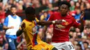 Striker Crystal Palace, Wilfried Zaha, beradu badan dengan bek Manchester United, Demitri Mitchell, pada laga Premier League di Stadion Old Trafford, Inggris, Minggu (21/5/2017). MU menang 2-0 atas Palace. (EPA/Tim Keeton)