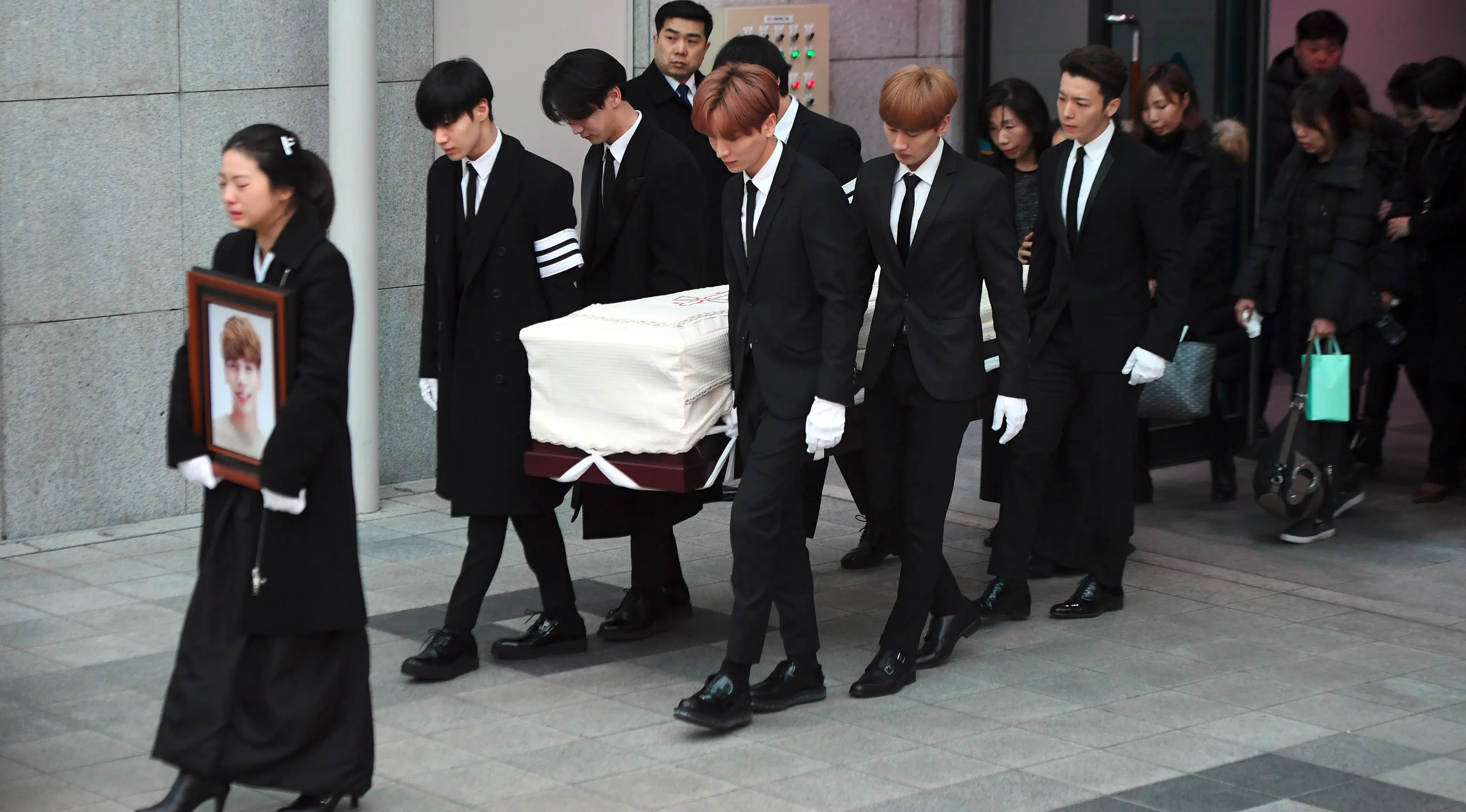 Kakak Jonghyun berjalan di depan pada pelepasan jenazah member boyband SHINee tersebut menuju tempat pemakaman dari Asan Hospital, Seoul, Kamis (21/12). Para member SHINee dan Super Junior mengangkat peti Jonghyun menuju mobil jenazah. (JUNG Yeon-Je/AFP)