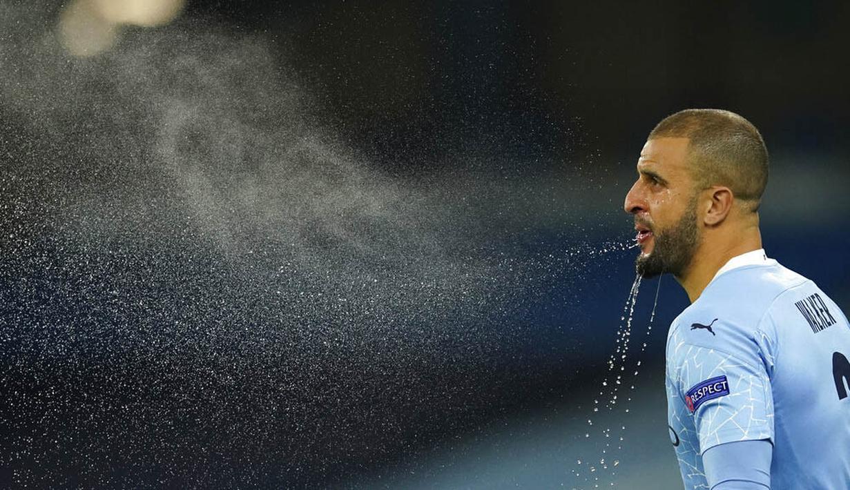 Bek Manchester City, Kyle Walker, menyemburkan air saat melawan Olympiakos pada laga Liga Champions di Stadion Etihad, Rabu (4/11/2020). Manchester City menang dengan skor 3-0. (AP/Dave Thompson)