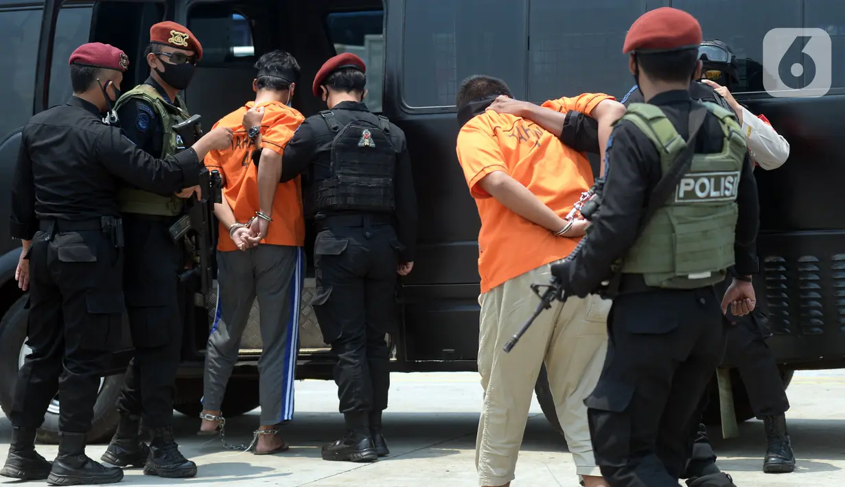 Anggota Densus 88 Antiteror menggiring terduga teroris masuk ke dalam mobil saat tiba di Bandara Soekarno-Hatta, Tangerang, Banten, Kamis (18/3/2021). Polri memindahkan 22 terduga teroris jaringan kelompok Jamaah Islamiyah (JI) dari Jawa Timur ke Jakarta. (merdeka.com/Imam Buhori)