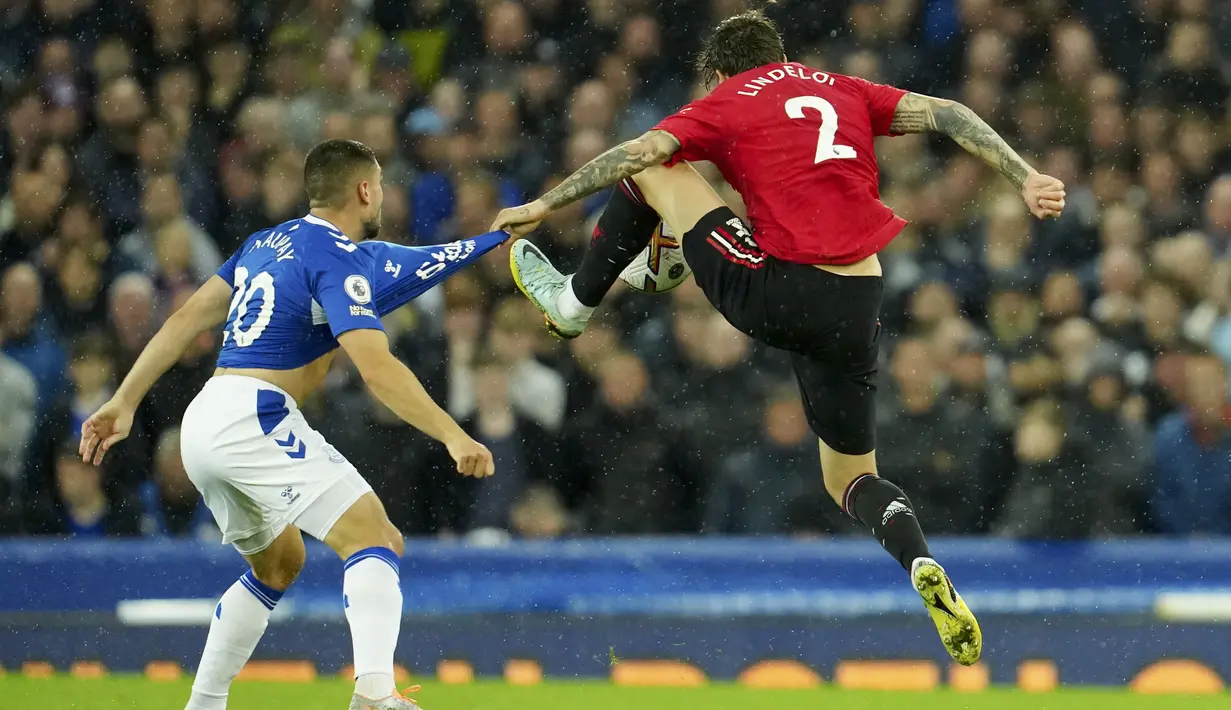 Bek Manchester United, Victor Lindelof berebut bola dengan pemain Everton Neal Maupay  pada pertandingan lanjutan Liga Inggris di Goodison Park, di Liverpool, Inggris, Senin (10/10/2022). Kemenangan ini membawa Man United naik ke posisi lima dengan koleksi lima poin. (AP Photo/Jon Super)
