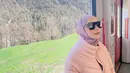 Berada di sebuah kereta, Sheza Idris mengenakan outfit super feminin. Yakni dengan mengenakan puffer jacket berwarna pink yang dipadukan dengan hijab lilac yang manis. (instagram/shezaidris)