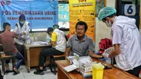 Sejumlah sopir bus menunggu untuk menjalani tes kesehatan di Terminal Kalideres, Jakarta, Rabu (21/12/2022). Memasuki arus libur Natal 2022 dan Tahun Baru 2023, seluruh sopir dan kondektur bus mengikuti tes kesehatan selama seminggu ke depan guna mencegah penggunaan narkoba serta untuk menjamin keselamatan perjalanan bagi para pemudik. (Liputan6.com/Angga Yuniar)