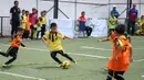 Seorang anak berusaha menggocek lawannya saat berlaga pada Liga Bola Indonesia. Pada kategori U-9, Bina Taruna masih menjadi pemuncak klasemen. (Bola.com/Vitalis Yogi Trisna)