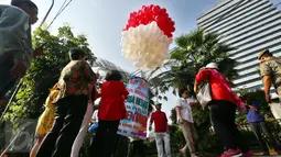 Warga mengambil gambar balon merah putih di halaman Balai Kota DKI Jakarta, Selasa (9/5). Menjelang sidang pembacaan putusan terhadap Basuki Tjahaja Purnama atau Ahok, kondisi pendopo Balai Kota tampak lengang. (Liputan6.com/Johan Tallo)