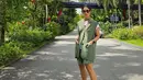 Dian Sastro tampil bak Gen Z saat padukan t-shirt putih dengan rok mini ruffle dan vest blazer hijau. Sneakers wedges dan sling bag bikin Dian tak terlihat sudah berusia 40an [@therealdisastr]