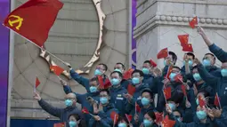 Para petugas medis yang datang dari luar Wuhan dalam membantu kota selama wabah virus corona COVID-19 megibarkan bendera China saat upacara perpisahan di Wuhan, Provinsi Hubei, China, Rabu (15/4/2020). Wuhan menjadi pusat penyebaran COVID-19. (AP Photo/Ng Han Guan)