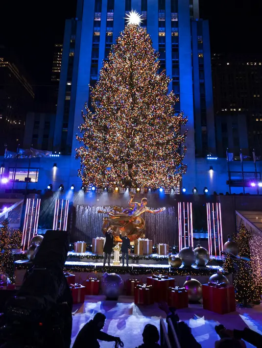 Lebih dari 50.000 lampu menghiasi Pohon Natal Rockefeller Center setinggi 75 kaki pada upacara tahunan pencahayaan di New York, Rabu (2/11/2020). Upacara yang digelar pada masa pandemi COVID-19 ini mewajibkan pengunjung untuk memakai masker, pembatasan waktu, dan jaga jarak. (AP Photo/Craig Ruttle)