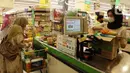 Kasir melayani warga yang berbelanja untuk kebutuhan bahan pokok akhir tahun di salah satu hypermarket, Jakarta, Sabtu (24/12/2022). Memasuki libur Natal dan Tahun Baru 2023, harga bahan pokok dan kebutuhan lainnya di supermarket masih stabil bahkan terdapat program promo. (merdeka.com/Imam Buhori)