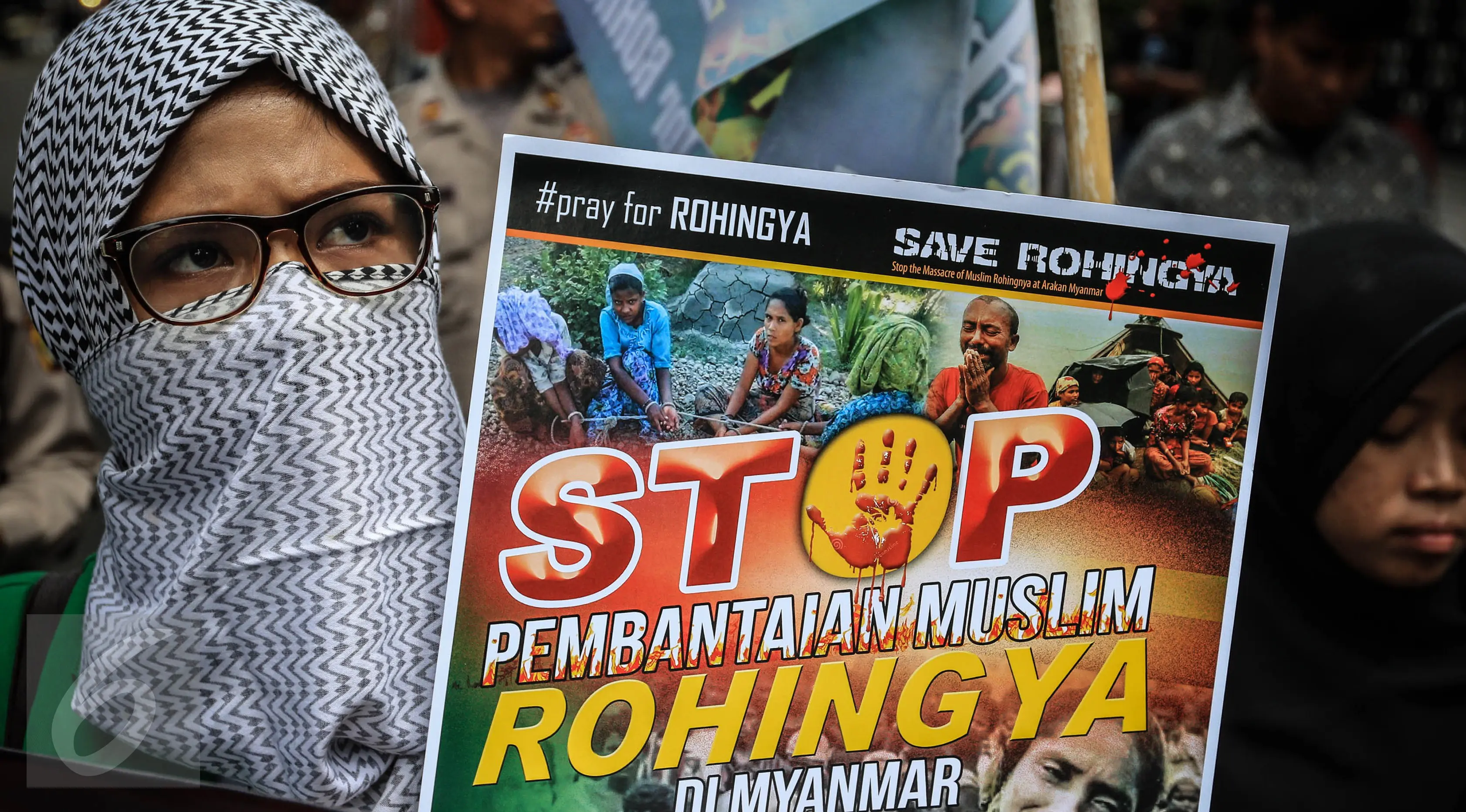 Massa yang mengatasnamakan Solidaritas Muslim Rohingya (SMR) membawa sebuah poster di depan Kedubes Myanmar, Jakarta, Jumat (25/11). Mereka menuntut pemerintah Myanmar segera menghentikan kekerasan terhadap muslim Rohingya. (Liputan6.com/Faizal Fanani)