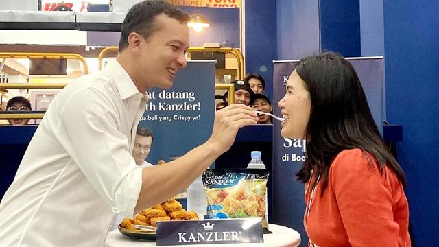 Nicholas Saputra memberikan suapan ke penggemar.