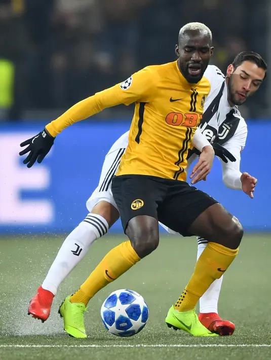 Pemain Young Boys, Nicolas Moumi Ngamaleu berebut bola dengan pemain Juventus, Mattia De Sciglio pada laga pamungkas Grup H Liga Champions di Stade de Suisse, Kamis (13/12). Juventus kalah 1-2 dari tuan rumah, Young Boys. (Fabrice COFFRINI/AFP)