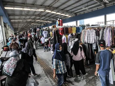 Pengunjung memilih pakaian di Skybridge Pasar Tanah Abang, Jakarta, Rabu (28/4/2021). Jumlah pengunjung dan aktivitas perdagangan kebutuhan pakaian Lebaran di jembatan multiguna ini mulai mengalami peningkatan memasuki 2 minggu menjelang Idul Fitri. (merdeka.com/Iqbal S. Nugroho)