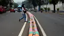 Warga menyeberangi Jalan TB Simatupang, Jakarta, Jumat (7/7). Jalan TB Simatupang sekitar perempatan Pasar Rebo menjadi berwarna dengan tampilan pot cat dan pembatas jalan warna warni. (Liputan6.com/Helmi Fithriansyah)