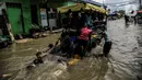 Sejumlah anak bermain air banjir rob di kawasan Muara Angke, Jakarta, Selasa (9/11/2021). Badan Penanggulangan Bencana Daerah (BPBD) DKI Jakarta memperkirakan puncak musim hujan dan potensi rob di Ibu Kota terjadi pada Januari hingga Februari 2022. (Liputan6.com/Faizal Fanani)