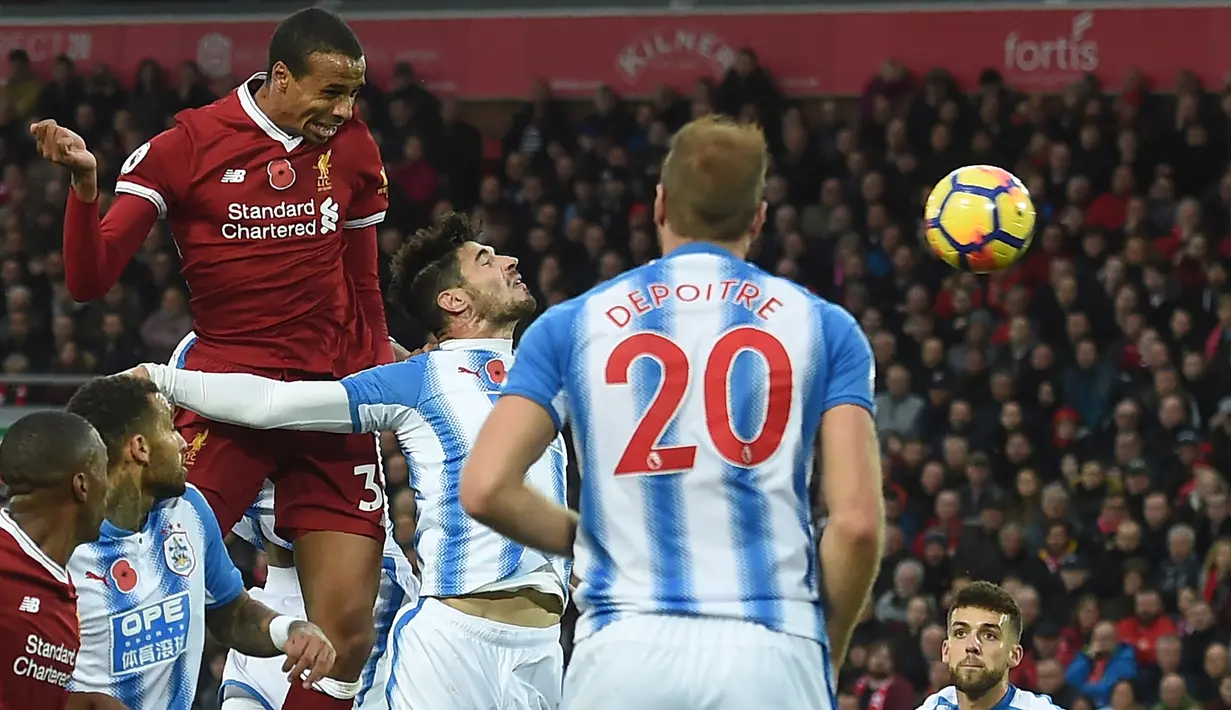 Pemain Liverpool, Joel Matip (kiri) menyundul bola saat berduel dengan pemain Huddersfield Town pada lanjutan Premier League di Stadion Anfield, Liverpool, (28/10/2017). Liverpool menang 3-0. (AFP/Paul Ellis)