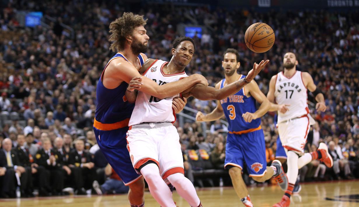 Pebasket Toronto Raptors  DeMar DeRozan (kanan) berebut bola dengan pebasket New York Knicks Robin Lopez  pada lanjutan NBA di Air Canada Centre, Toronto, Rabu(11/11/2015) WIB. Knicks kalahkan Raptors 111-109. (Reuters/Tom Szczerbowski-USA TODAY Sports)
