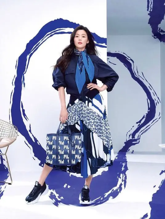 Seperti dalam potret kali ini, Jun Ji Hyun tampil menawan dalam outfit serba FILA.  Bintang dari KDrama Legend of The Blue Sea ini mengenakan emerald jacket seharga Rp6,1 juta, emerald skirt Rp 3,6 juta, emerald scarf Rp 1 juta, dan smasher sneaker Rp 2,1 juta. (Instagram/gianjunfp).