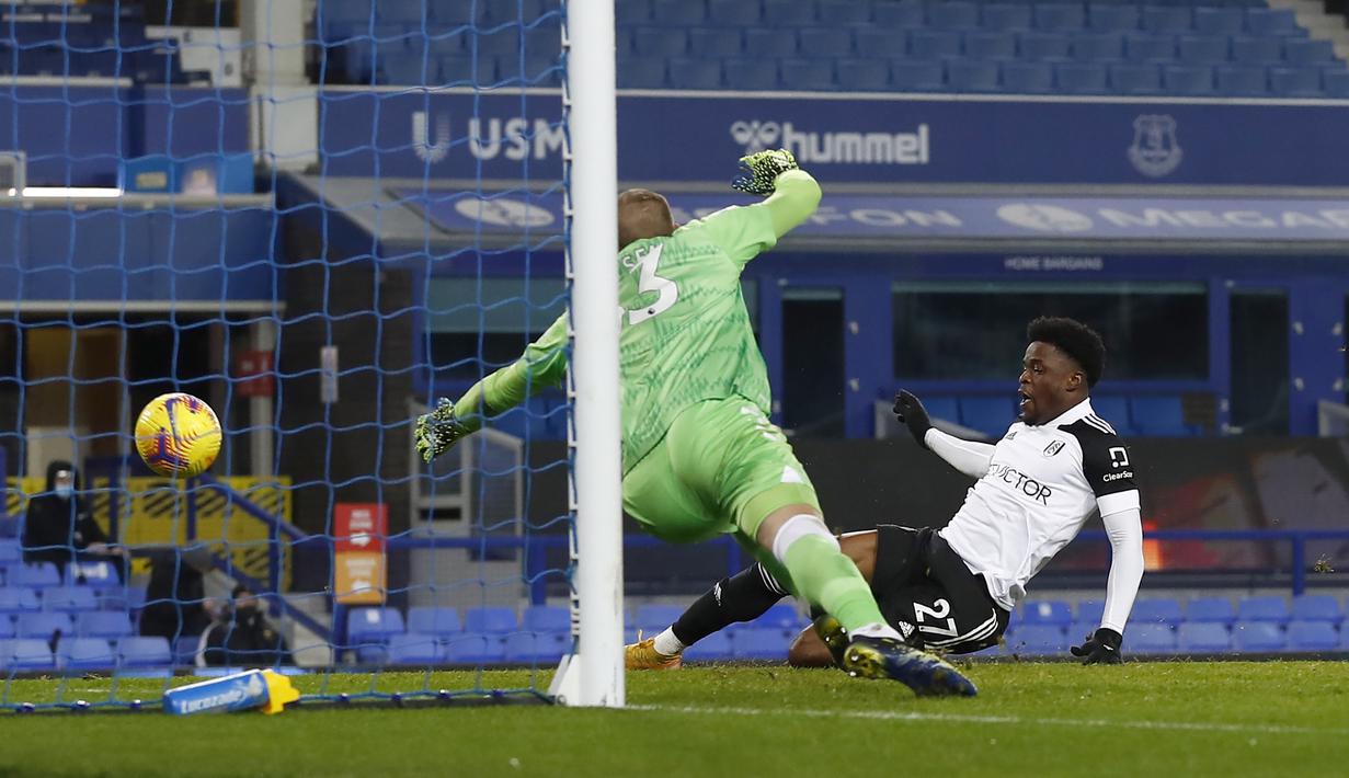 Striker Fulham, Josh Maja (kanan) melepaskan tendangan yang berbuah gol pertama timnya ke gawang Everton dalam laga lanjutan Liga Inggris 2020/21 pekan ke-24 di Goodison Park, Liverpool, Minggu (14/2/2021). Fulham menang 2-0 atas Everton. (AP/Jason Cairnduff/Pool)