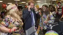 Pangeran Harry mengangkat dua telepon sekaligus saat menjadi broker dalam acara amal tahunan ICAP di London, Rabu (7/12). Pangeran Harry menjadi broker dadakan untuk mengumpulkan dana amal dari 60 kantor di seluruh dunia. (REUTERS/Geoff Pugh/Pool)
