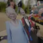 Fans membawa potongan foto Raja Charles III dan Ratu Camilla. (AP Photo/Alberto Pezzali)