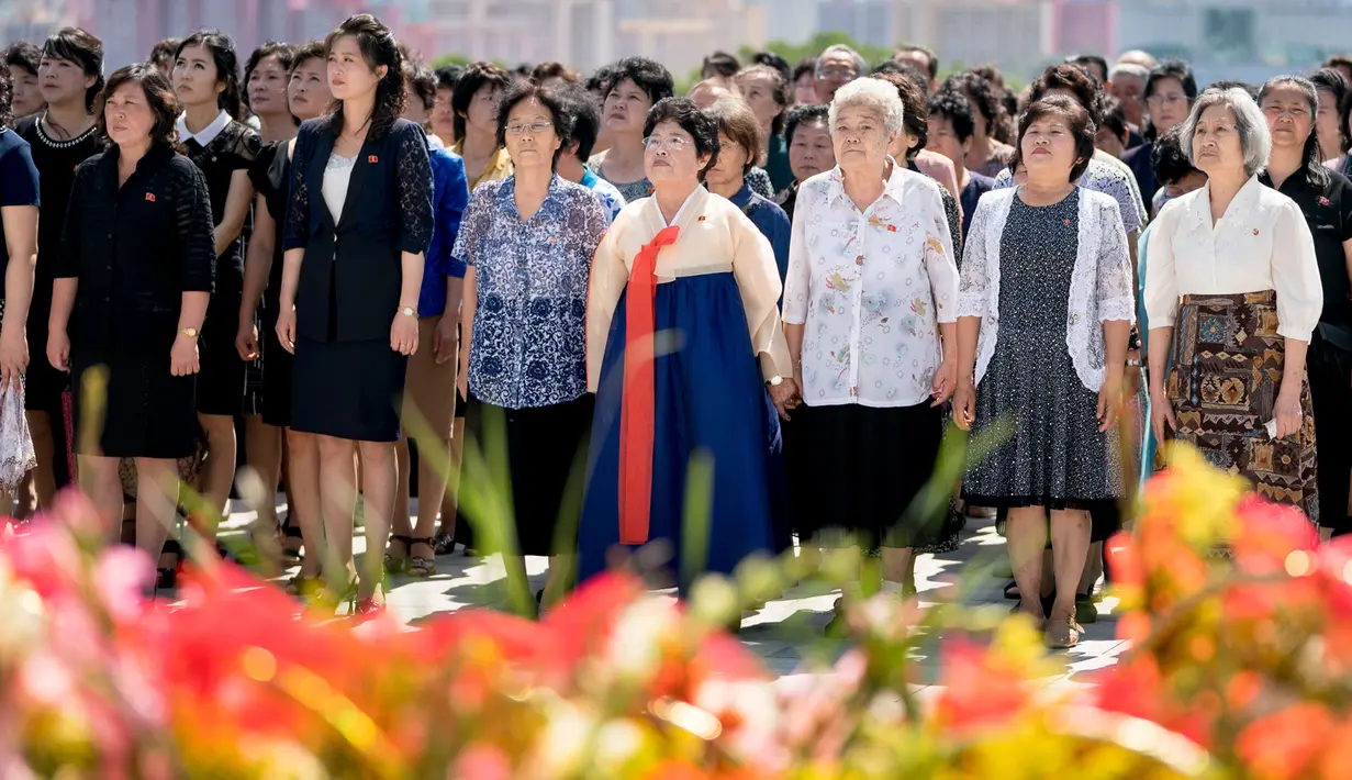Penduduk memberikan penghormatan di depan patung pemimpin Korea Utara, Kim Il Sung dan Kim Jong Il di Bukit Mansu, Pyongyang, pada peringatan 24 tahun kematian Kim Il Sung, Sabtuu (7/7). Kim Il Sung meninggal pada 8 Juli 1994. (AP/Andrew Harnik, Pool)