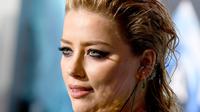 Ekspresi Amber Heard saat menghadiri premier film terbarunya, "Aquaman" di Los Angeles, California, AS (12/12). Amber Heard tampil seksi dengan gaun jaring-jaring menerawang hijau. (AFP Photo/Kevin Winter)