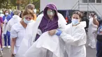 Staf medis membantu pasien bernapas melalui masker oksigen setelah kebakaran di bagian ICU COVID-19 Rumah Sakit Penyakit Menular di pelabuhan Laut Hitam Constanta, Rumania (1/10/2021). Pihak berwenang mengatakan kebakaran telah menewaskan sembilan pasien COVID-19 di ICU. (AP Photo/Costin Dinca)