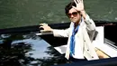 Harry Styles melambaikan tangan saat ia tiba di dermaga Hotel Excelsior selama Venice Film Festival 2022 ke-79 di Venesia, Italia (5/9/2022). Pria 29 tahun itu berperan sebagai Jack Dalam film “Don’t Worry Darling,”. (AFP/Marco Bertorello)