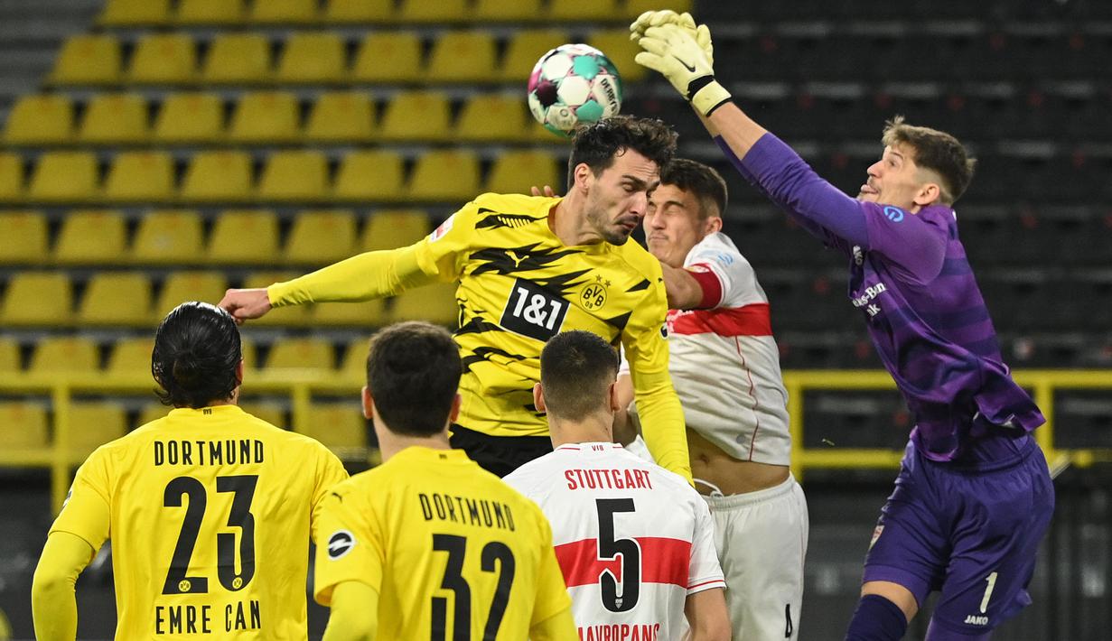 Kiper Stuttgart, Gregory Kobel, duel udara dengan bek Borussia Dortmund, Mats Hummels, pada laga Bundesliga di Stadion Signal Iduna Park, Minggu (13/12/2020). Stuttgart menang dengan skor 5-1. (AFP/Ina Fassbender)