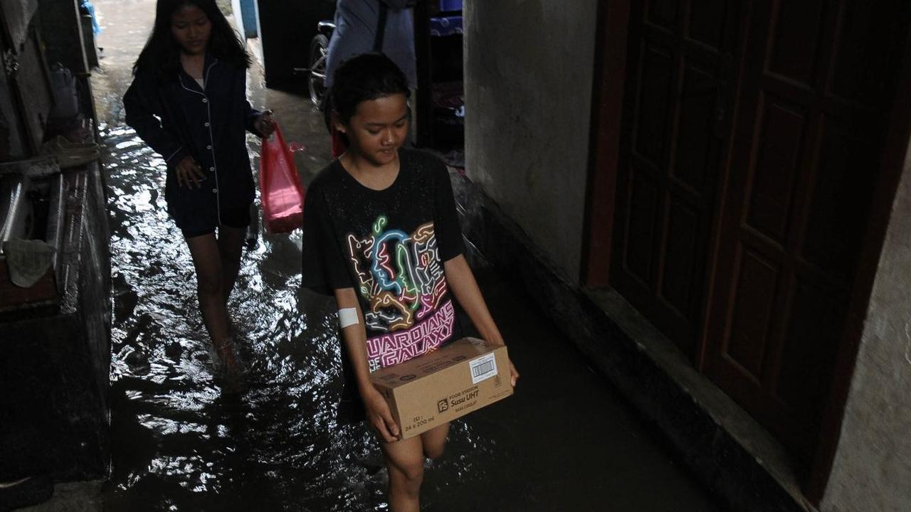 Warga beraktivitas di tengah banjir yang merendam lingkungan RT 16/04, Kelurahan Rawa Terate, Kecamatan Cakung, Jakarta Timur, Rabu (31/1/2024). Hujan yang mengguyur sejak malam  hari membuat pemukiman warga di Kelurahan Rawa Terate terendam banjir. Foto: