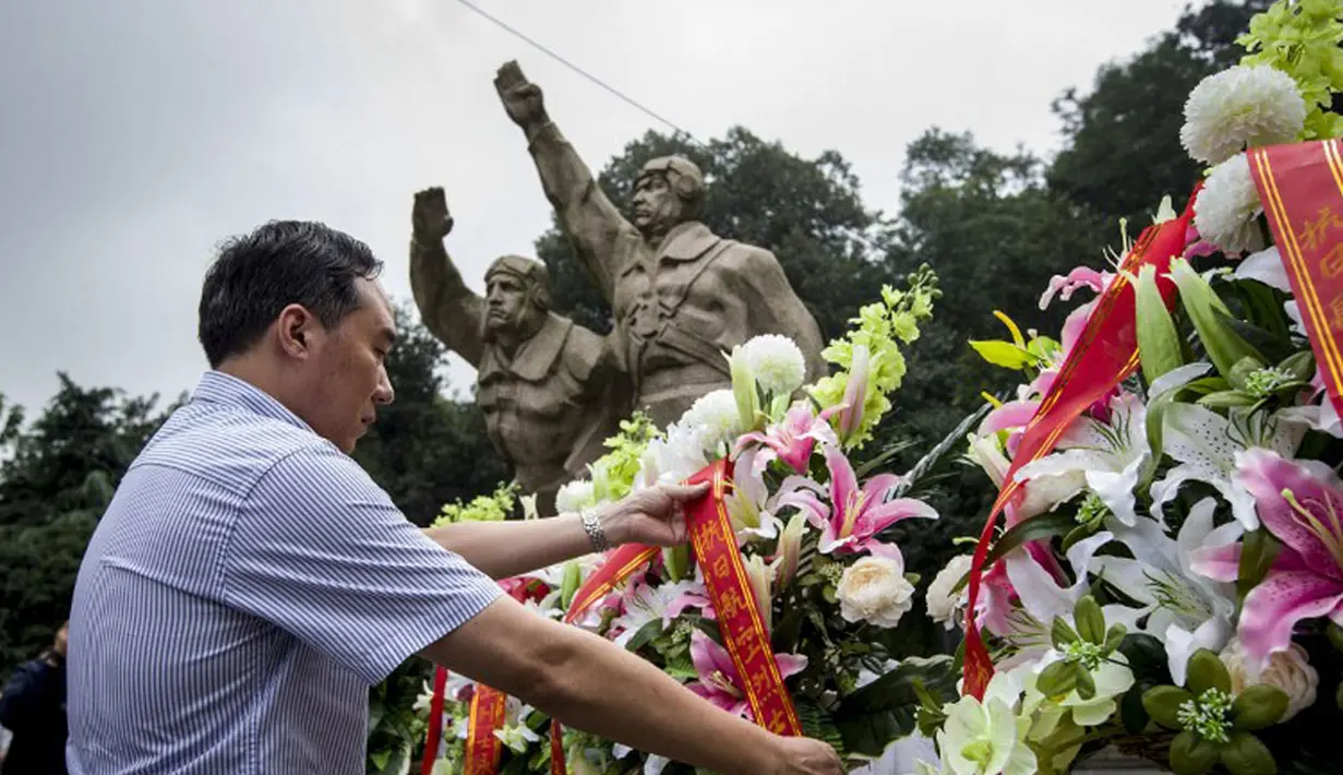 Seorang pria menempatkan bunga untuk orang-orang yang gugur di Aviation Martir Memorial dalam peringatan 69 tahun kemenangan rakyat Tiongkok melawan Jepang di Perang Dunia II, Nanjing, (3/9/2014). (AFP PHOTO/STR)