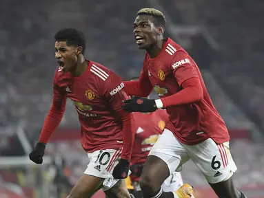 Penyerang Manchester United, Marcus Rashford (kiri) berselebrasi dengan rekannya Paul Pogba setelah mencetak gol pada menit 90+4 ke gawang Wolverhampton Wanderers pada pertandingan lanjutan Liga Inggris di Stadion Old Trafford, Rabu (30/12/2020). MU menang 1-0. (Michael Regan, Pool via AP)