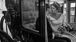 Foto resmi pernikahan Putri Eugenie dan Jack Brooksbank di Windsor Castle yang dirilis Istana Kensington pada 13 Oktober 2018. Putri Eugenie dan Jack Brooksbank berciuman di dalam kereta kuda setelah pernikahan mereka (Alex BRAMALL/BUCKINGHAM PALACE/AFP)