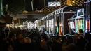 Sejumlah penumpang bersiap untuk naik kereta wisata yang dihiasi lampu Natal di Bogota (20/12/2019). Meyambut Hari Natal, kereta wisata di Kolombia membuat cara unik dengan memasangkan lampu warna-warni agar menjadi daya tarik penumpang. (AFP Photo/Juan Barreto)