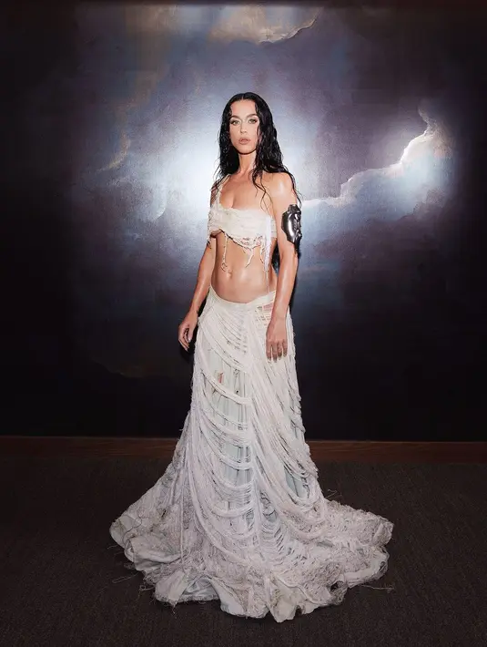 Katy Perry memukau dengan penampilan memukau dari koleksi Musim Semi 2025 Who Decides War. Pakaiannya menyalurkan pengaruh Victoria dengan sentuhan modern. Gaunnya, yang dibuat dalam warna gading yang halus, menampilkan kain yang rusak, kain yang tidak simetris, dan detail yang compang-camping, menawarkan penghormatan yang sangat indah terhadap mode era Victoria. [@katyperry]