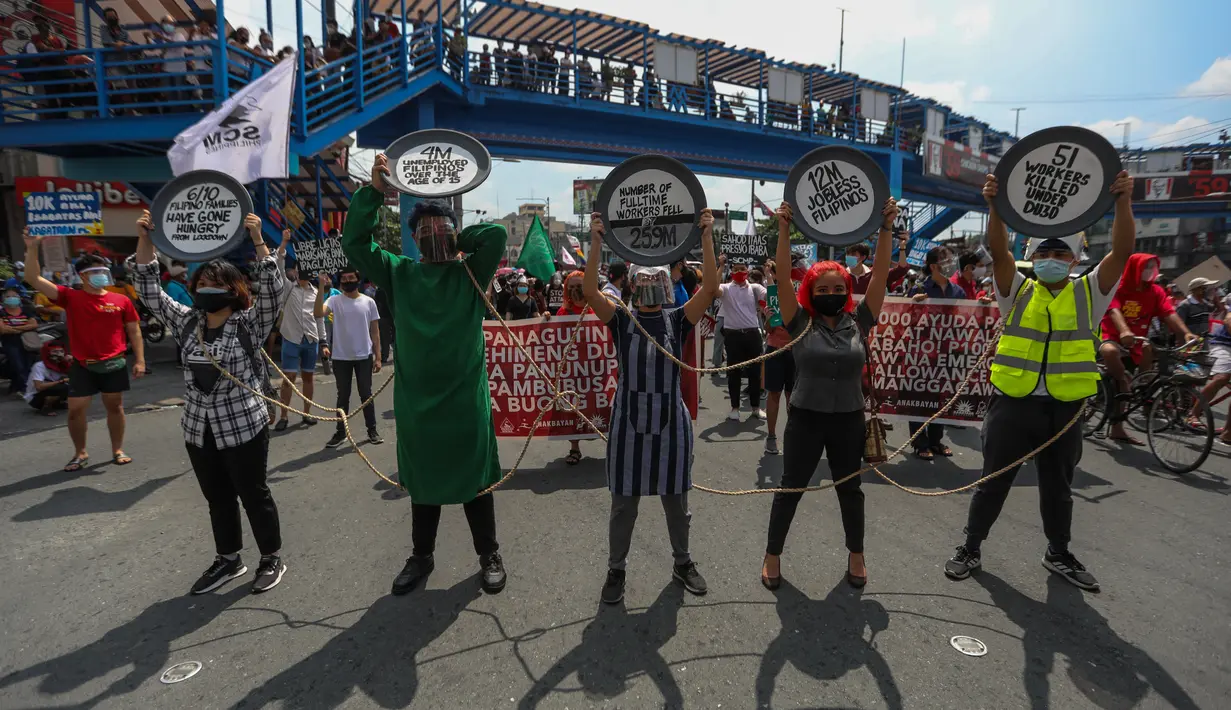 Para pengunjuk rasa memegang plakat selama protes untuk memperingati Hari Buruh di Manila pada Sabtu (1/5/2021). Setiap tahun, Hari Buruh Internasional atau May Day dirayakan di berbagai negara pada 1 Mei. (Maria Tan / AFP)