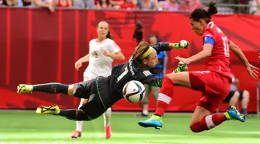 Kiper Swiss, Gaelle Thalmann melompat menghalau bola tendangan penyerang Kanada, Christine Sinclair saat Piala Dunia wanita 2015 di BC Place Stadium, Senin (22/6/2015). Kanada menang 1-0 atas Swiss lewat gol Josee Belanger. (Reuters/Anne Marie Sorvin)