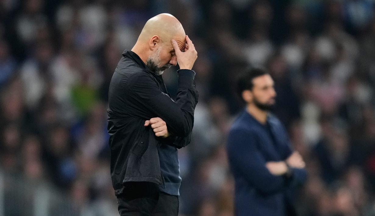 Pelatih Manchester City, Pep Guardiola tampak lesu setelah ditaklukkan Real Madrid pada laga leg pertama babak 16 besar Liga Champions di Stadion Santiago Bernabeu (12/3/2026). (AP Photo/Jose Breton)