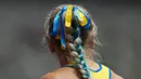 Anna Ryzhykova dari Ukraina mengenakan pita biru dan kuning di rambutnya yang terkepang saat memenangkan nomor lari gawang 400 meter putri pada Olimpiade Tokyo 2020 di Tokyo, Jepang, 31 Juli 2021. (AP Photo/Petr David Josek)