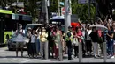 Kerumunan penduduk berjejer di trotar yang diberi pembatas di sepanjang jalan Orchard Road, Singapura, Senin (11/6). Tampak mereka menunggu kedatangan Presiden Amerika Serikat, Donald Trump. (AP/Joseph Nair)