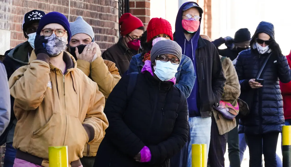 Antrean warga kota di sepanjang blok untuk menerima alat tes cepat COVID-19 di rumah secara gratis di Philadelphia, Senin (20/12/2021). Setiap penduduk kota dapat mengambil dua kit di klinik pop-up departemen kesehatan. (AP Photo/Matt Rourke)