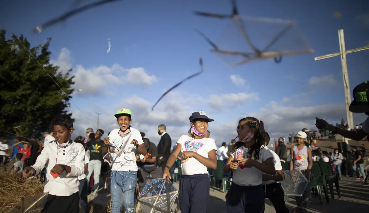 Anak-anak menerbangkan layang-layang dalam acara peringatan 400 tahun permukiman kumuh Petare di Caracas, Venezuela (17/2/2021). Kota ini didirikan pada 1621 dengan nama San Jose de Guanarito. (AP Photo/Ariana Cubillos)