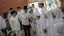 Menteri Ketenagakerjaan Hanif Dhakiri bersalaman dengan anak-anak saat menghadiri pembukaan Nusantara Bertauhid di Ciganjur, Jakarta, Kamis (14/3). Acara ini mengusung tema 'Khataman Alquran untuk Persatuan Indonesia'. (Liputan6.com/Faizal Fanani)