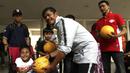 Pelatih Timnas Indonesia U-23, Indra Sjafri, memberikan bola kepada anak-anak yang datang ke Stadion Madya, Jakarta, Rabu (13/3). Sejumlah anak dari Yayasan Rumah Harapan Indonesia datang menemui Timnas U-23 (Bola.com/Vitalis Yogi Trisna)