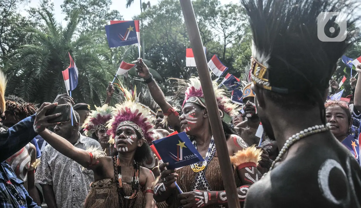 Pendukung partai politik mengenakan baju adat Papua saat turut meramaikan pawai di depan Kantor Komisi Pemilihan Umum (KPU) RI, Jakarta, Senin (1/8/2022). Sebanyak sembilan partai politik dijadwalkan turut meramaikan hari pertama Pendaftaran Peserta Pemilu 2024 yang dibuka mulai hari ini. (merdeka.com/Iqbal S. Nugroho)