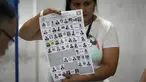Seorang petugas pemilu menunjukkan surat suara saat penghitungan suara dimulai setelah pemungutan suara ditutup selama pemilihan umum di Guatemala City, Minggu, 25 Juni 2023. (AP Photo/Moises Castillo)