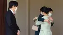 Putri Mako dari Jepang memeluk saudara perempuannya Putri Kako sebelum meninggalkan rumahnya di Istana Akasaka, Tokyo, Selasa (26/10/2021). Putri Mako secara resmi kehilangan status kerajaannya setelah menikahi kekasih semasa kuliah, Kei Komuro pada Selasa (26/10). (Koki Sengoku/Kyodo News via AP)