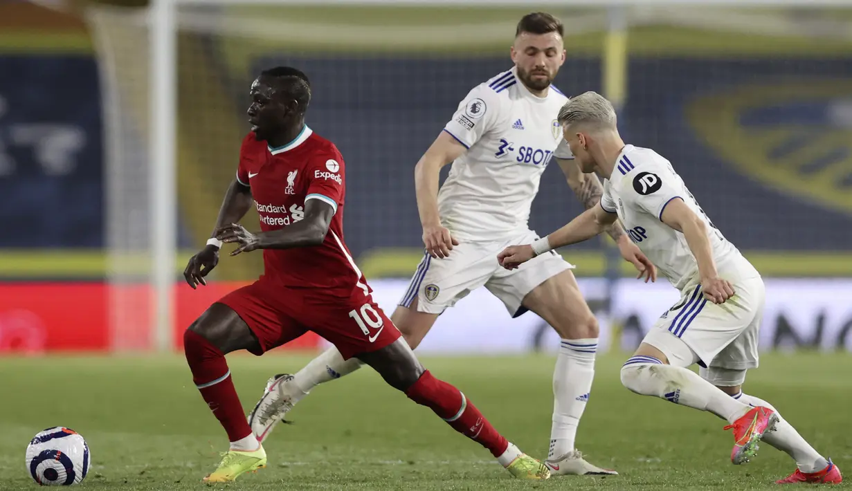Pemain Liverpool Sadio Mane (kiri) menggiring bola mencoba melewati pemain Leeds United Ezgjan Alioski (kanan) pada pertandingan Liga Inggris di Stadion Elland Road, Leeds, Inggris, Senin (19/4/2021). Pertandingan berakhir dengan skor 1-1. (Clive Brunskill/Pool via AP)
