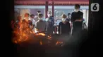 Keluarga dan kerabat menyaksikan proses kremasi jenazah di Krematorium Cilincing, Jakarta, Kamis (29/7/2021). Sejak 19 Juli 2021, Krematorium Cilincing juga melayani kremasi jenazah dengan protokol COVID-19. (Liputan6.com/Helmi Fithriansyah)
